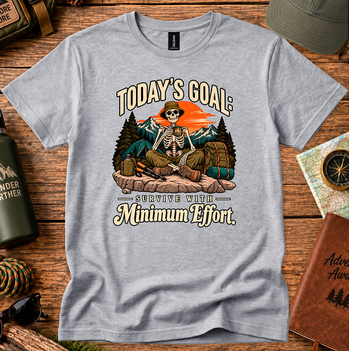 Today's Goal Minimum Effort T-shirt with a seated skeleton camper, tent, backpack, mountains and sunset