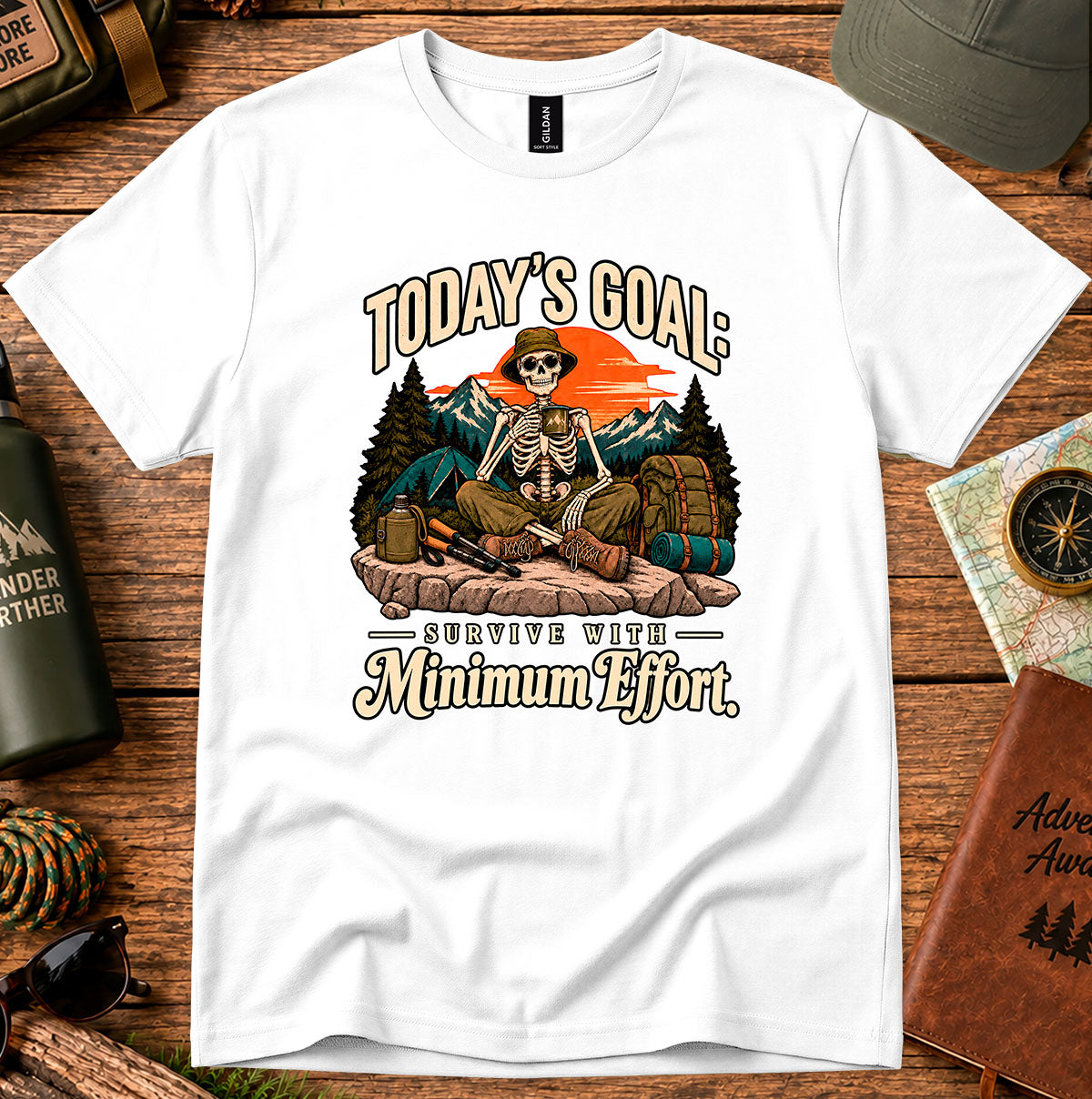 Today's Goal Minimum Effort T-shirt with a seated skeleton camper, tent, backpack, mountains and sunset