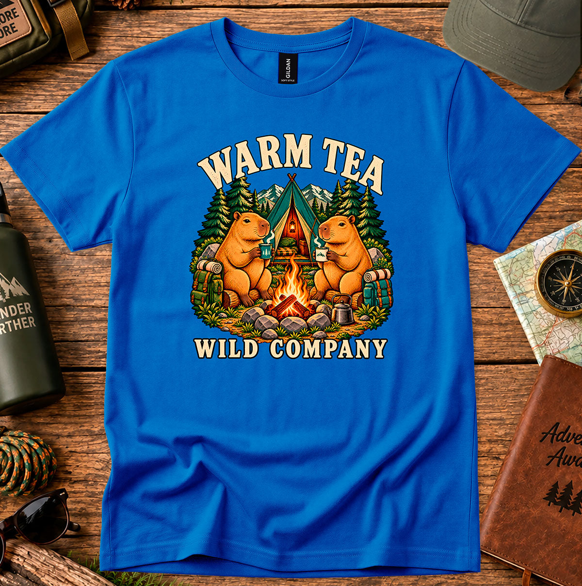 Warm Tea Wild Company T-shirt showing two capybaras with mugs beside a campfire, tent and pine trees