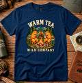 Warm Tea Wild Company T-shirt showing two capybaras with mugs beside a campfire, tent and pine trees