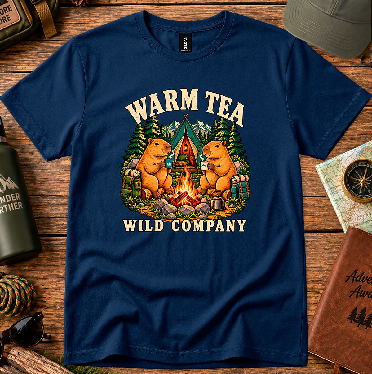 Warm Tea Wild Company T-shirt showing two capybaras with mugs beside a campfire, tent and pine trees