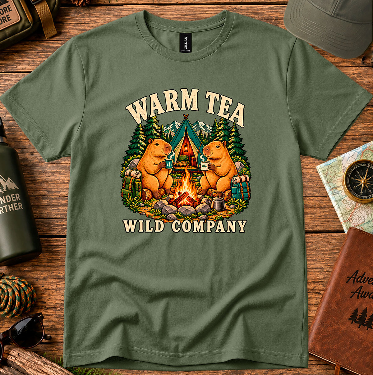 Warm Tea Wild Company T-shirt showing two capybaras with mugs beside a campfire, tent and pine trees