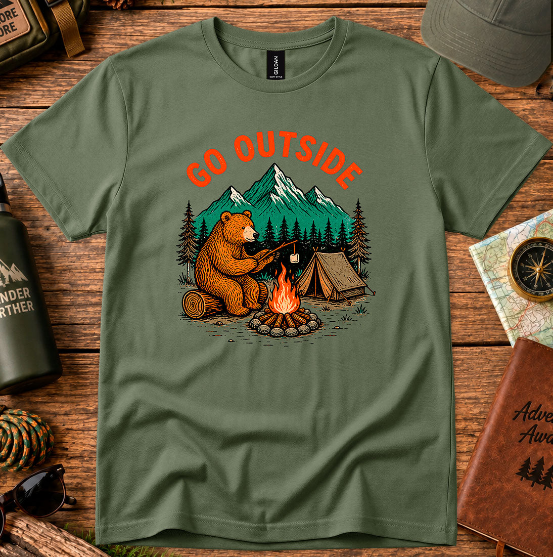 T-shirt featuring a bear warming its paws by a campfire with Go Outside lettering