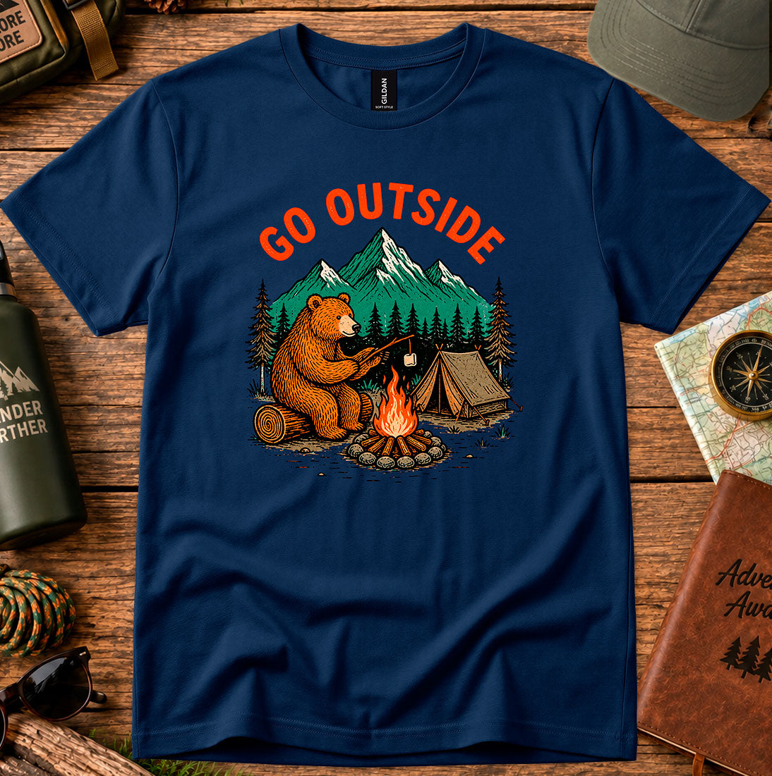 T-shirt featuring a bear warming its paws by a campfire with Go Outside lettering