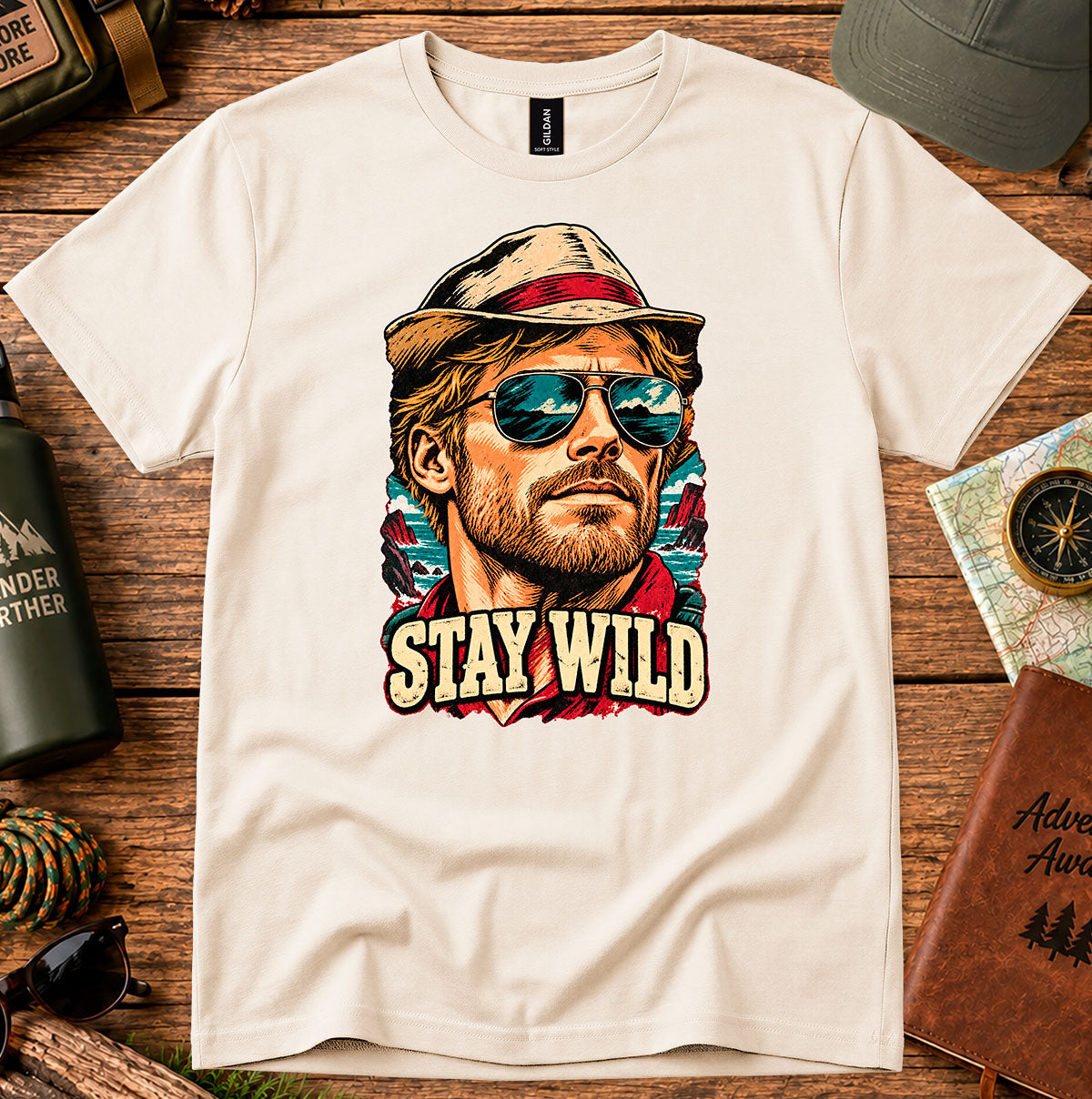 Cream T-shirt featuring a retro portrait of a man wearing a cap and sunglasses above STAY WILD lettering