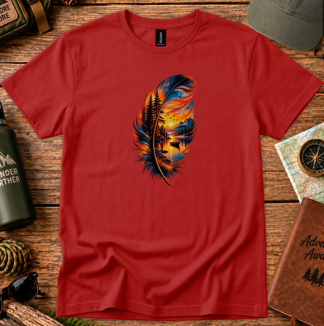 T-shirt featuring a hand-painted feather containing a lakeside sunset