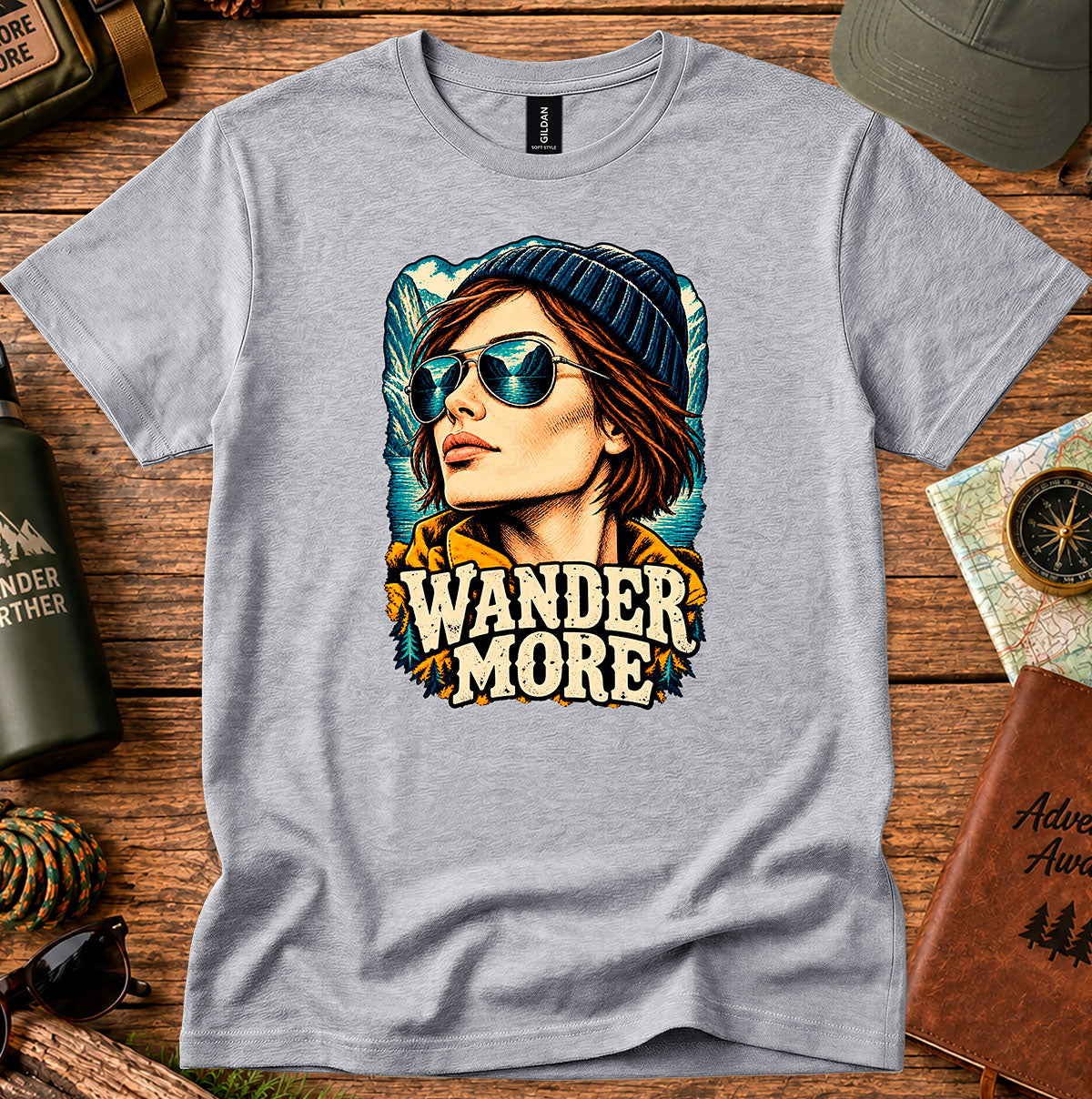 Wander More T-shirt showing a traveller in a beanie with distant mountain peaks