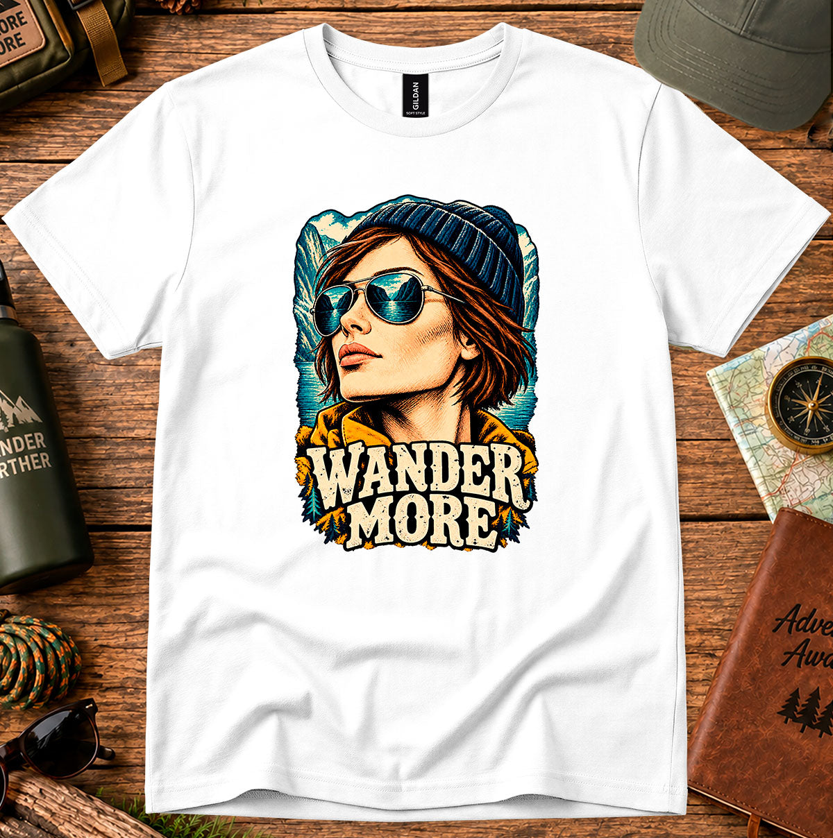 Wander More T-shirt showing a traveller in a beanie with distant mountain peaks
