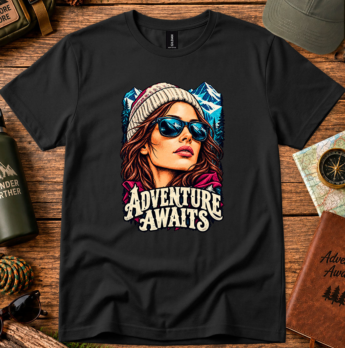 Adventure Awaits T-shirt showing an explorer in sunglasses framed by mountain peaks
