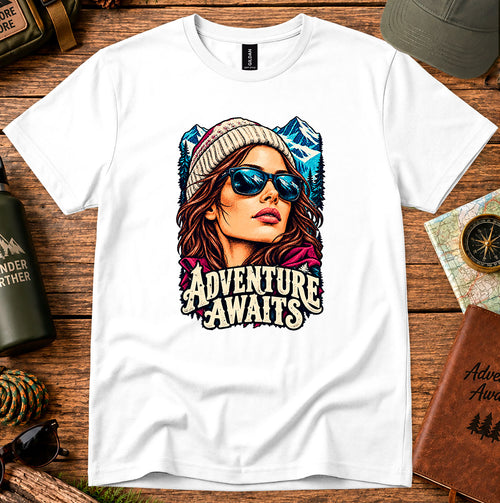 Adventure Awaits T-shirt showing an explorer in sunglasses framed by mountain peaks