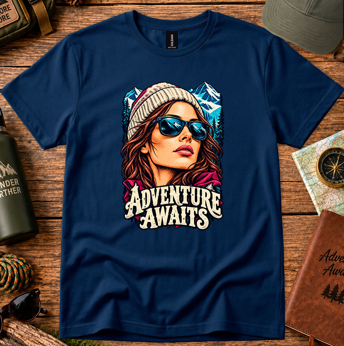 Adventure Awaits T-shirt showing an explorer in sunglasses framed by mountain peaks