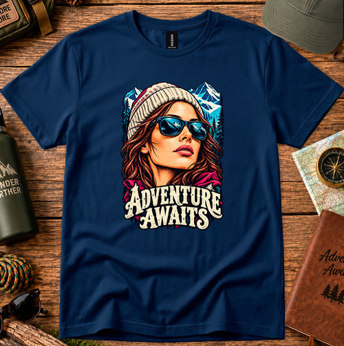 Adventure Awaits T-shirt showing an explorer in sunglasses framed by mountain peaks