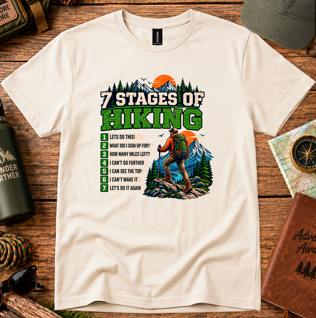 T-shirt featuring a Stages of Hiking checklist with a hiker and sunset
