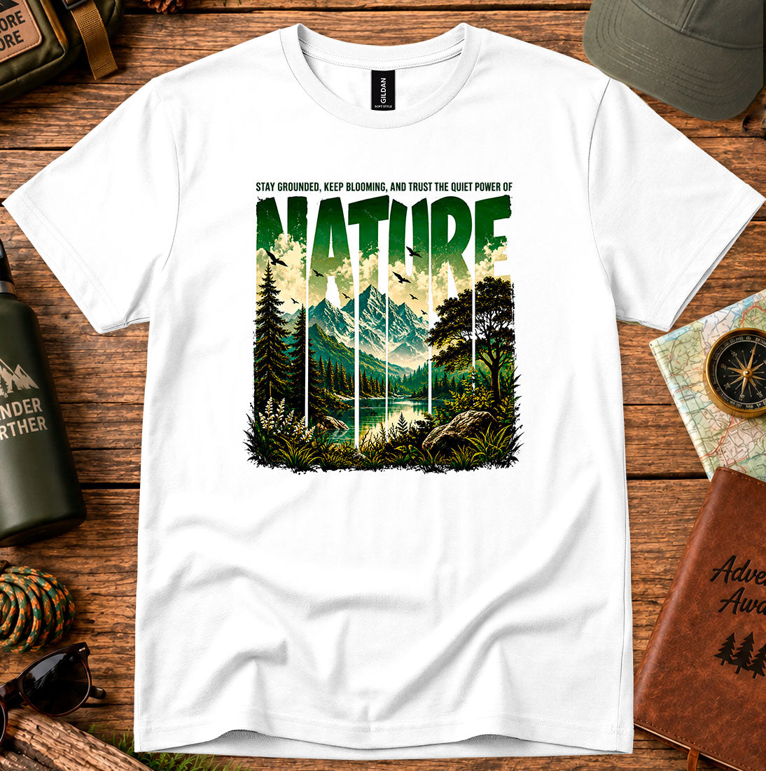T-shirt featuring a layered landscape of pine trees and distant mountains