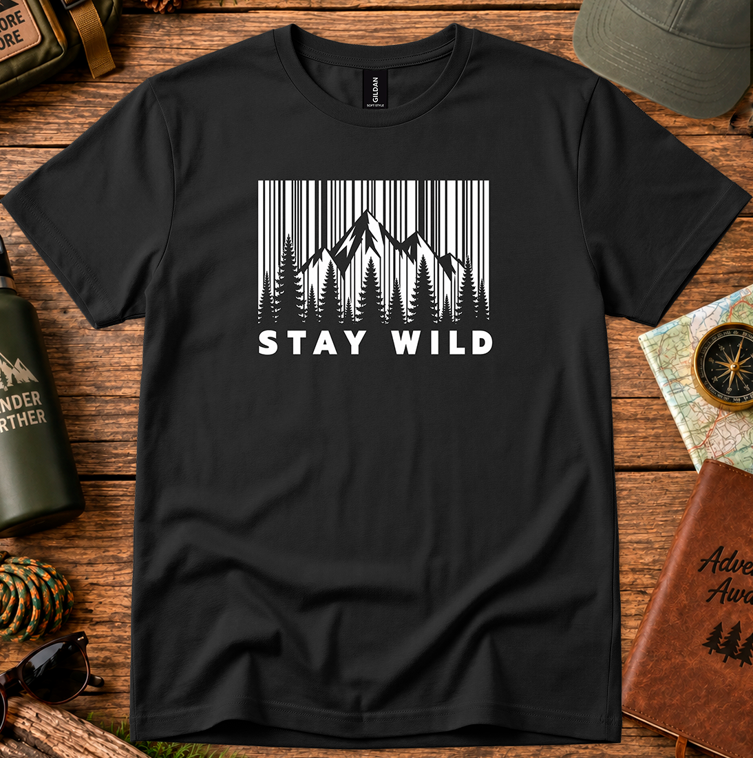 T-shirt featuring a monochrome mountain and pine tree design with Stay Wild lettering