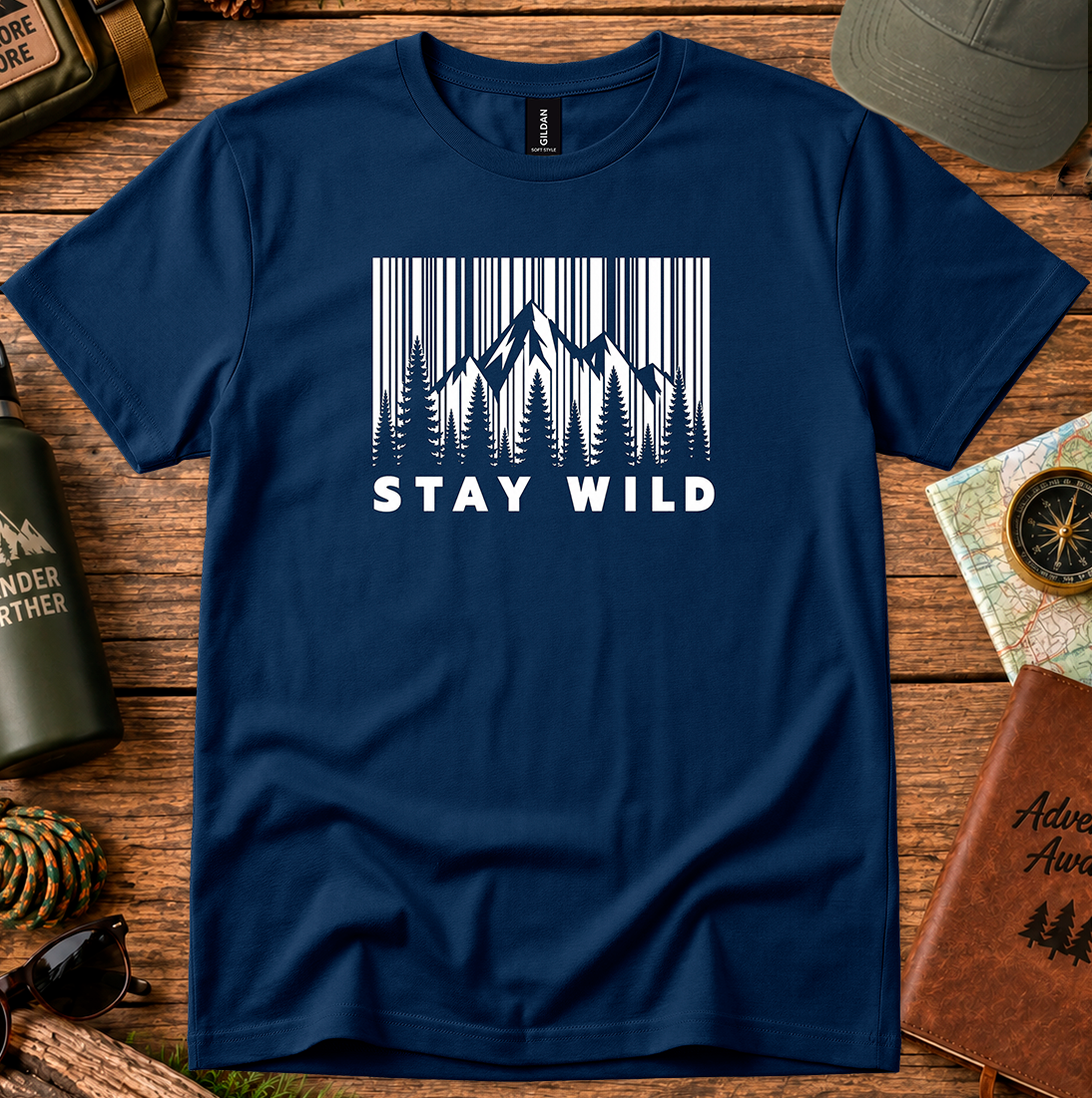 T-shirt featuring a monochrome mountain and pine tree design with Stay Wild lettering