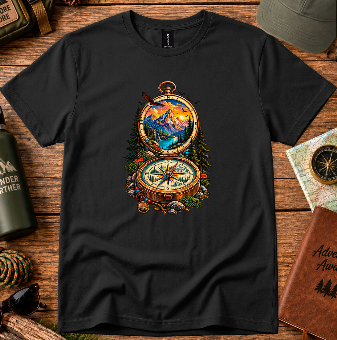 T-shirt featuring an open vintage compass framing a mountain lake and sunset